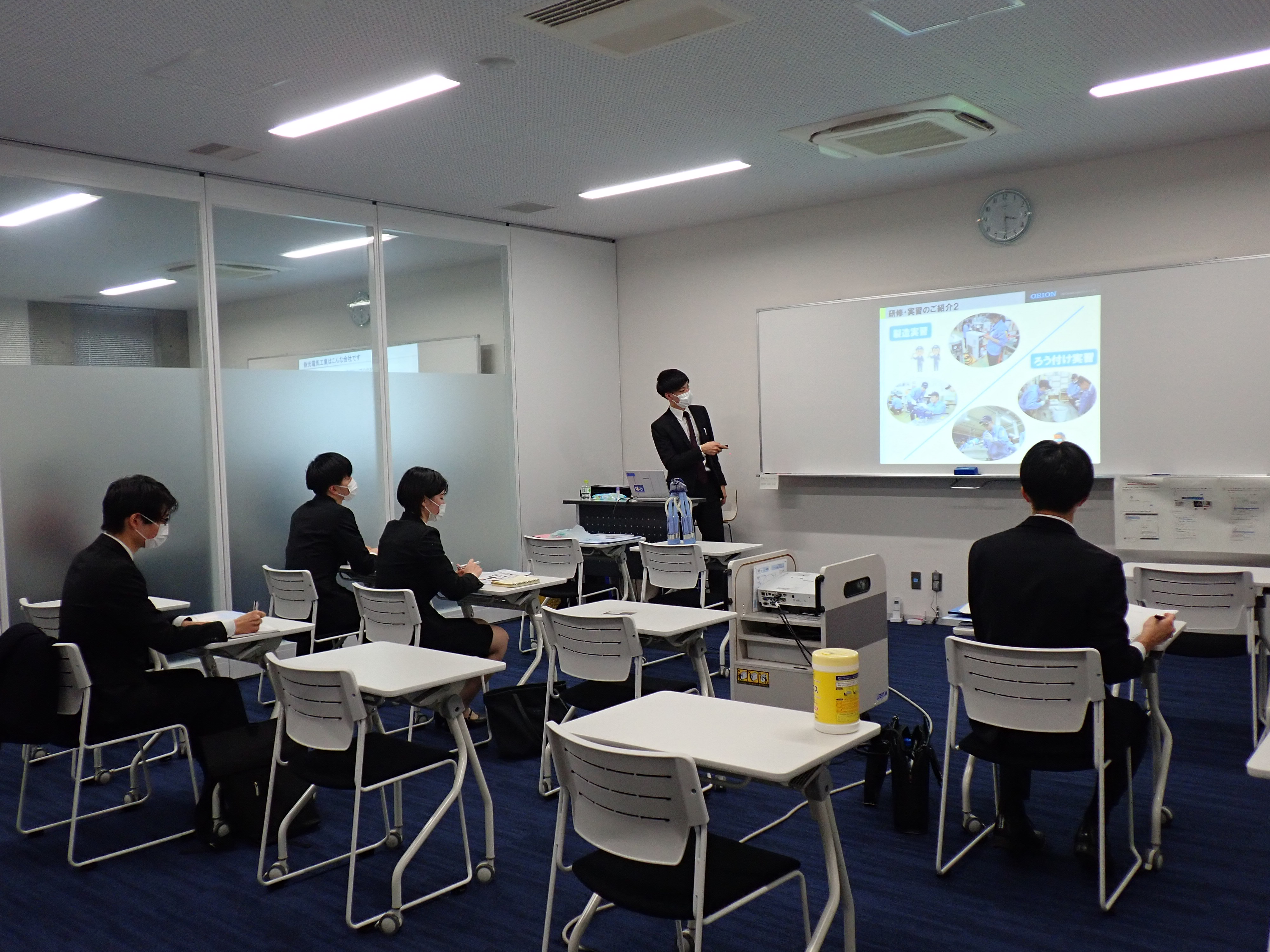 各ブースで企業担当者の説明を聞く学生たちの写真