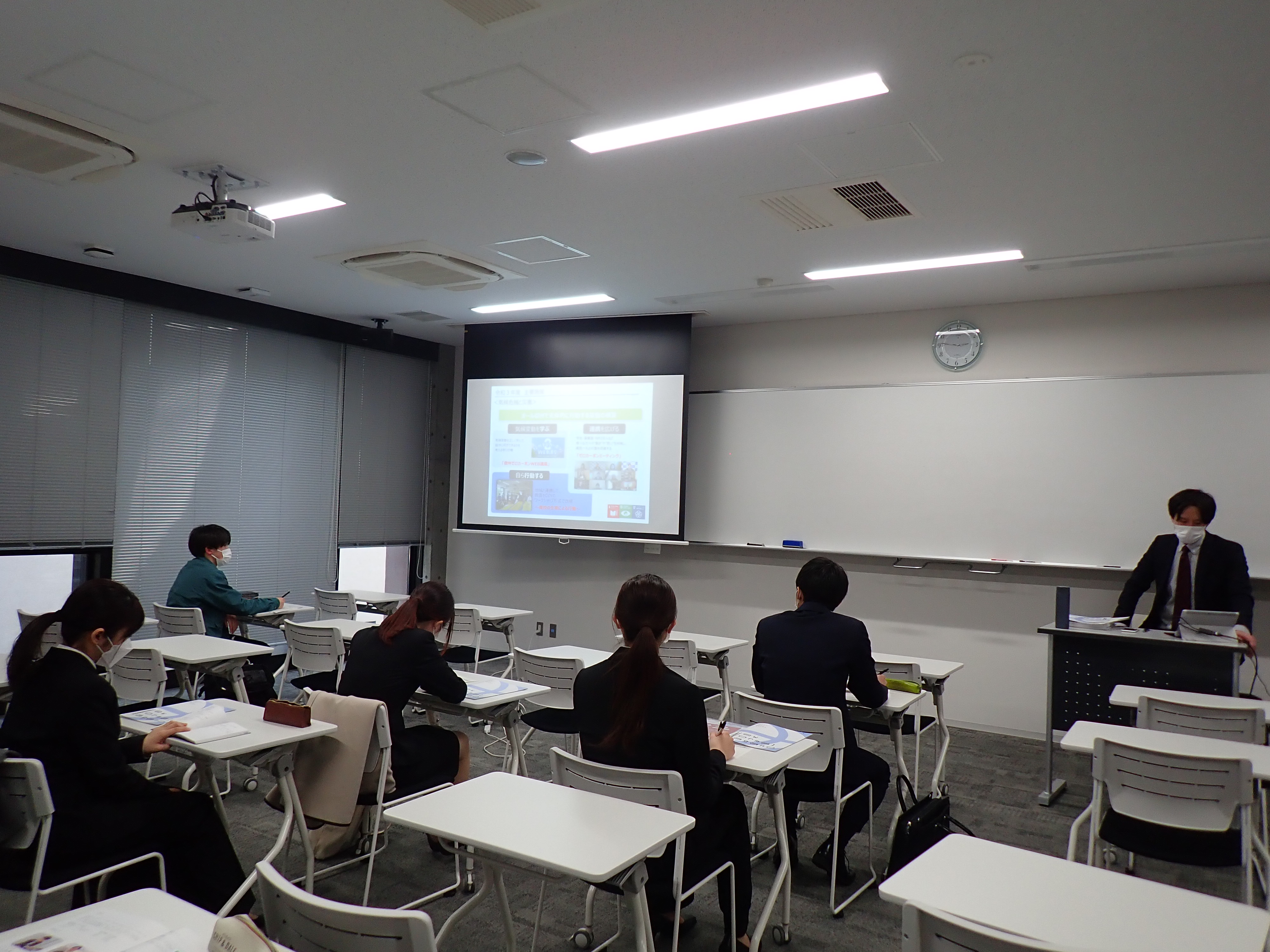 各ブースで企業担当者の説明を聞く学生たちの写真
