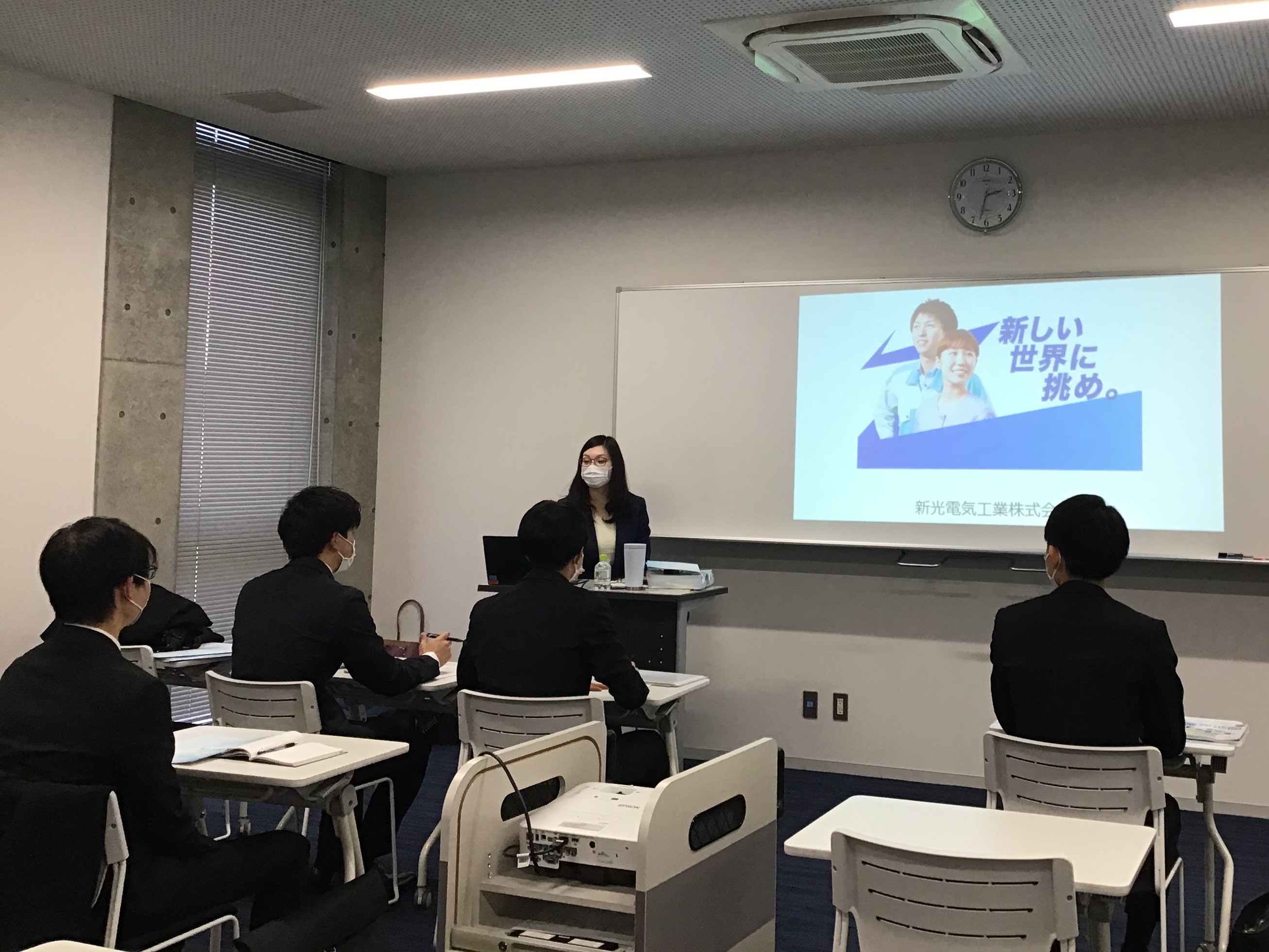 各ブースで企業担当者の説明を聞く学生たちの写真