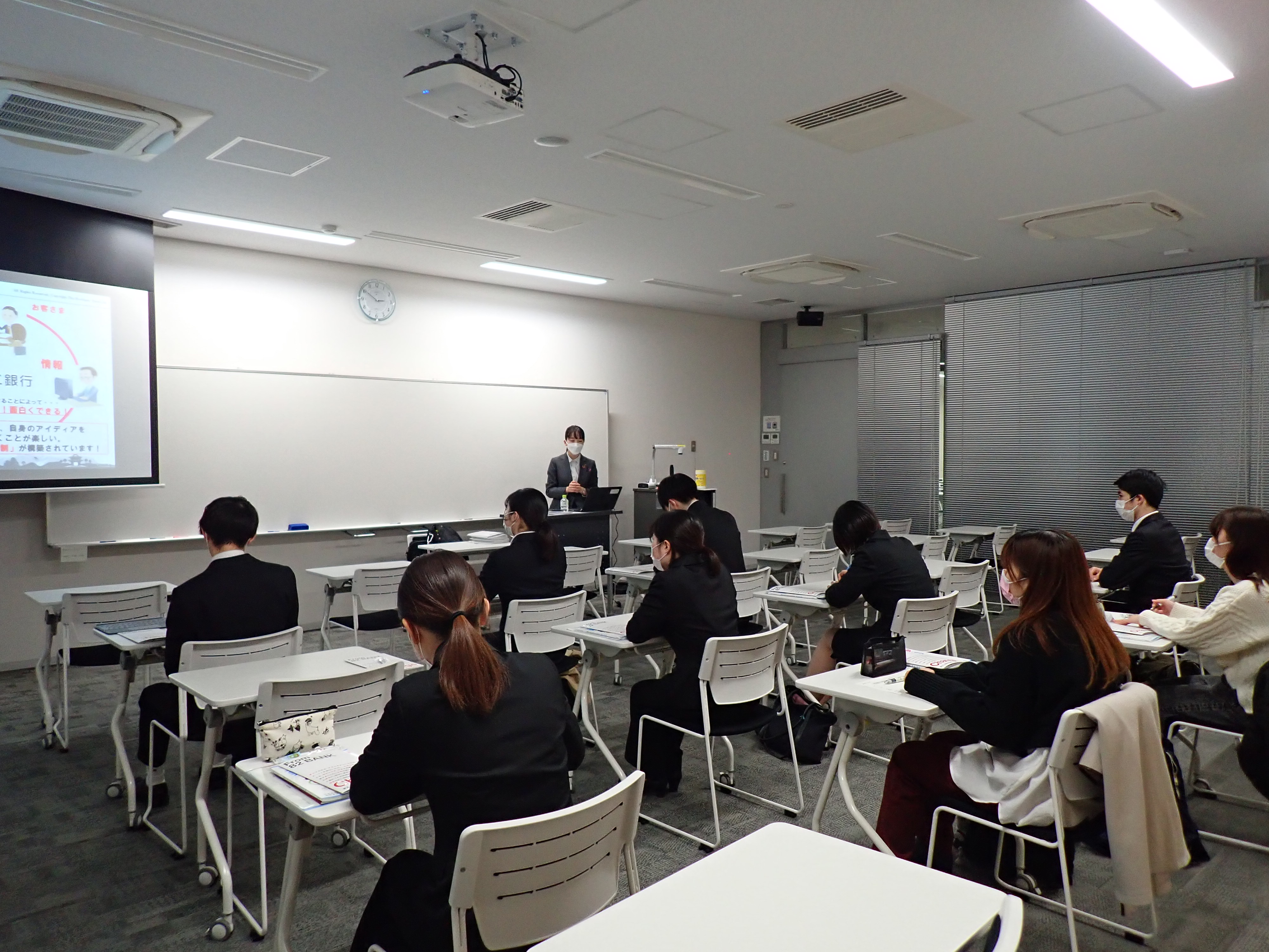各ブースで企業担当者の説明を聞く学生たちの写真