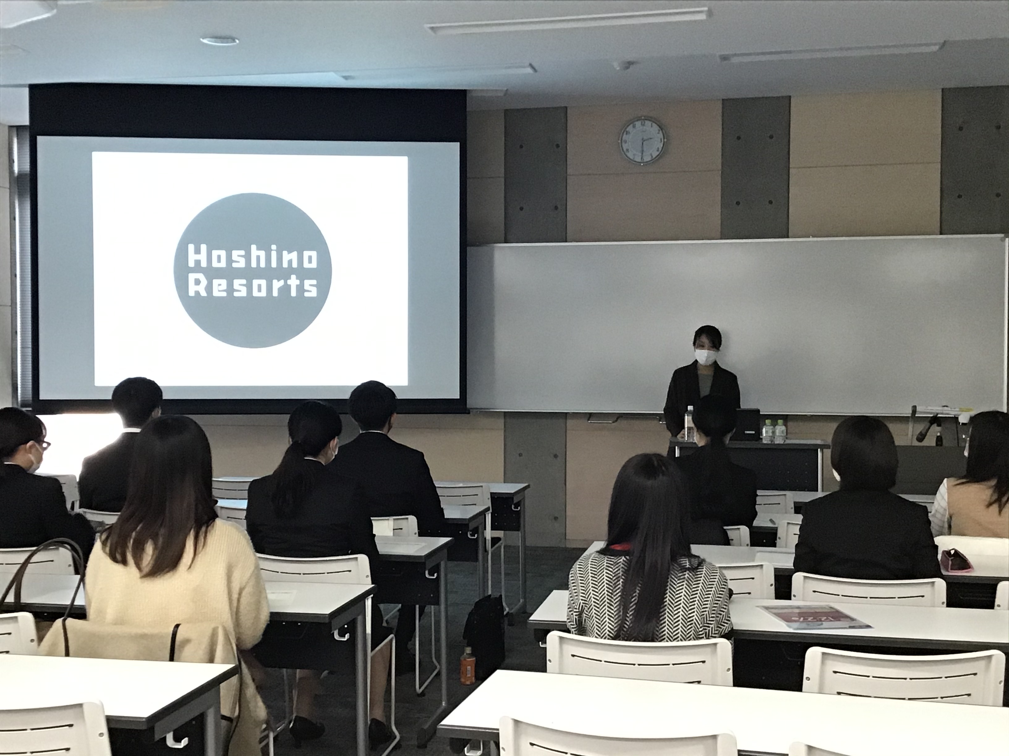 各ブースで企業担当者の説明を聞く学生たちの写真