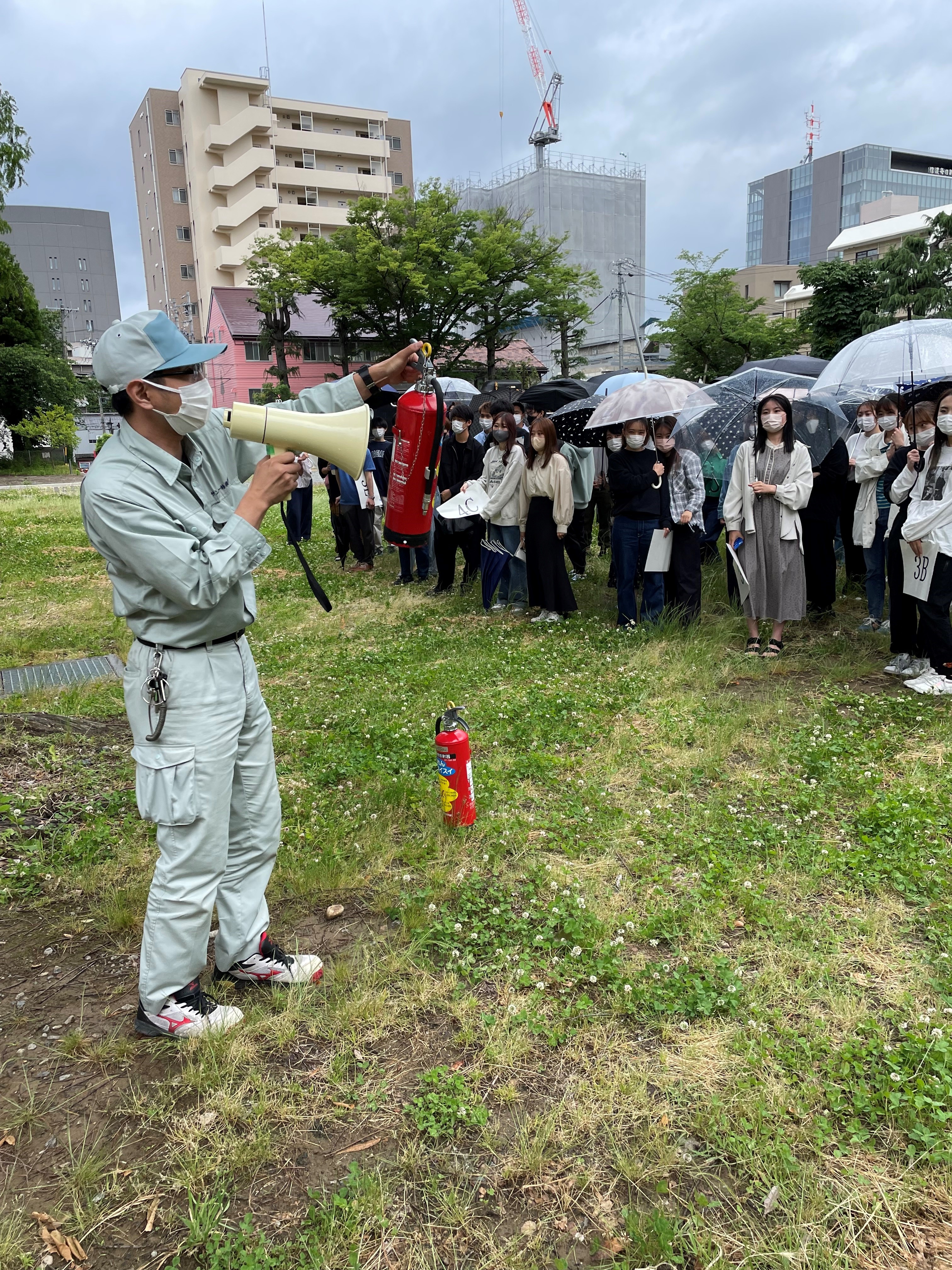 消火器取り扱いの説明を受ける様子　