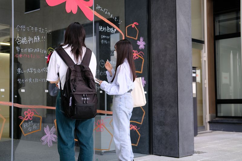 正面玄関に入試への意気込みなどを書いている様子