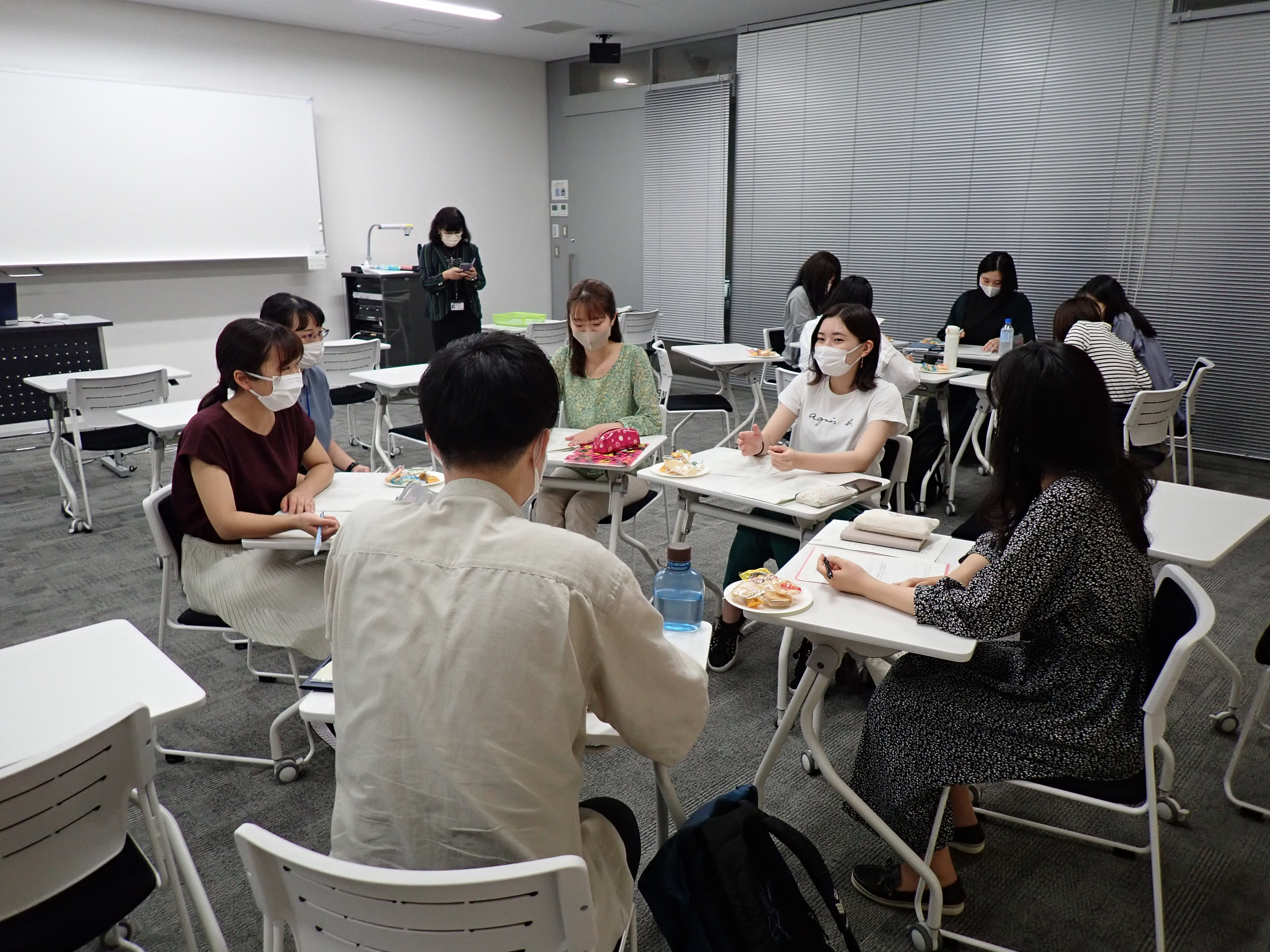 グループごとに机を寄せて話し合っている学生たちの写真