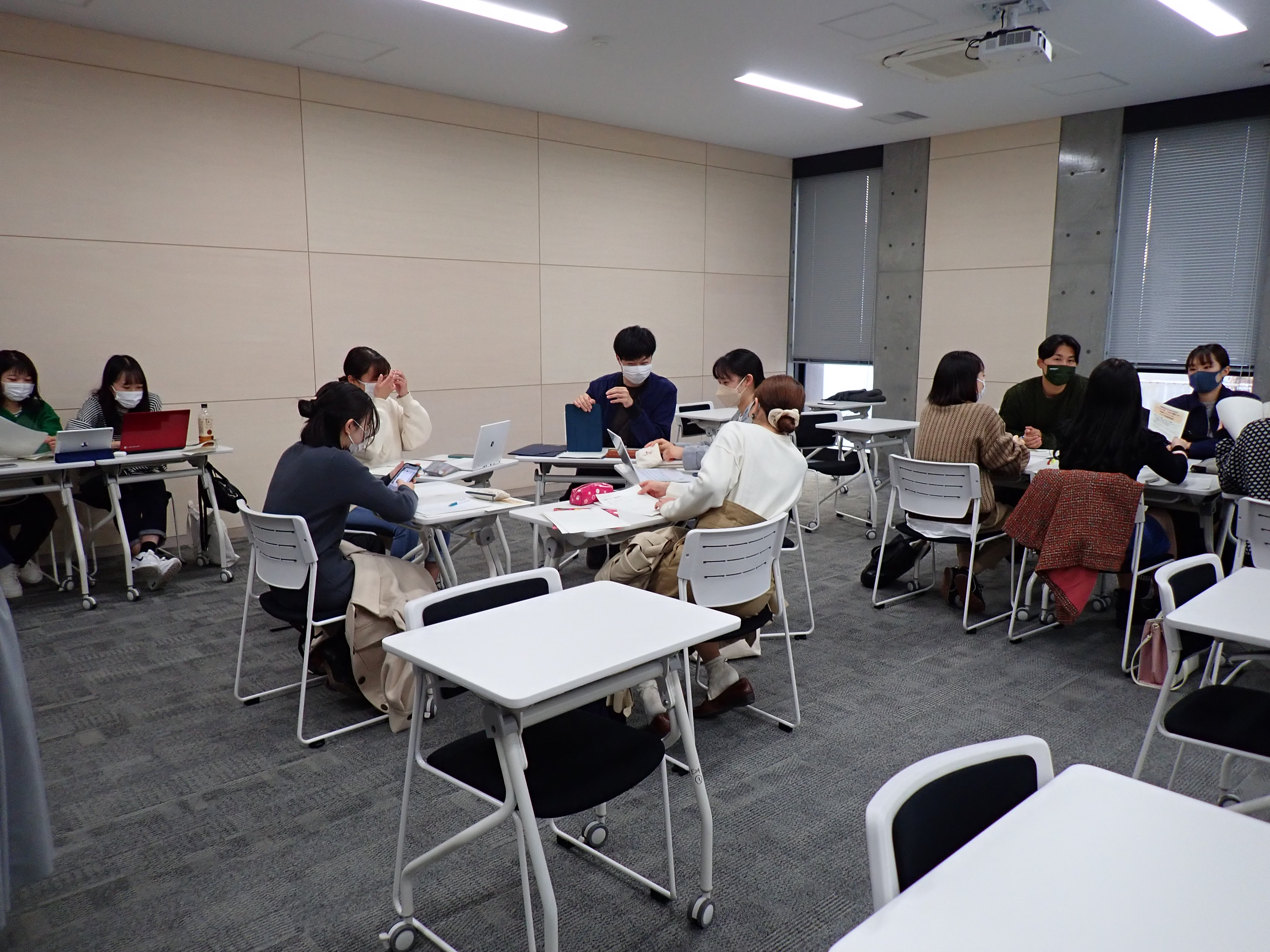 グループごとに机を寄せて話し合っている学生たちの写真