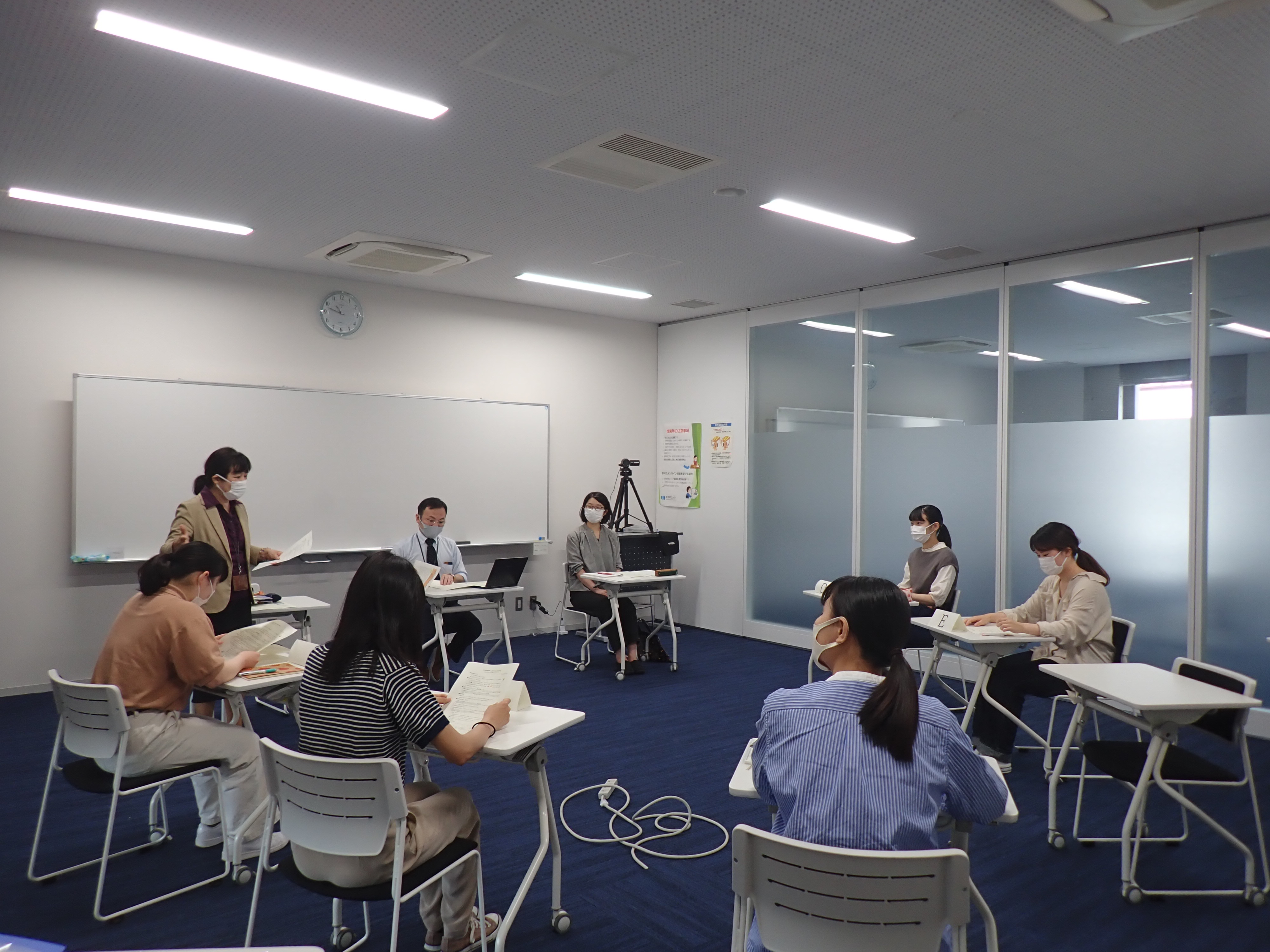 学生がメモをとりながら話を聞いている写真