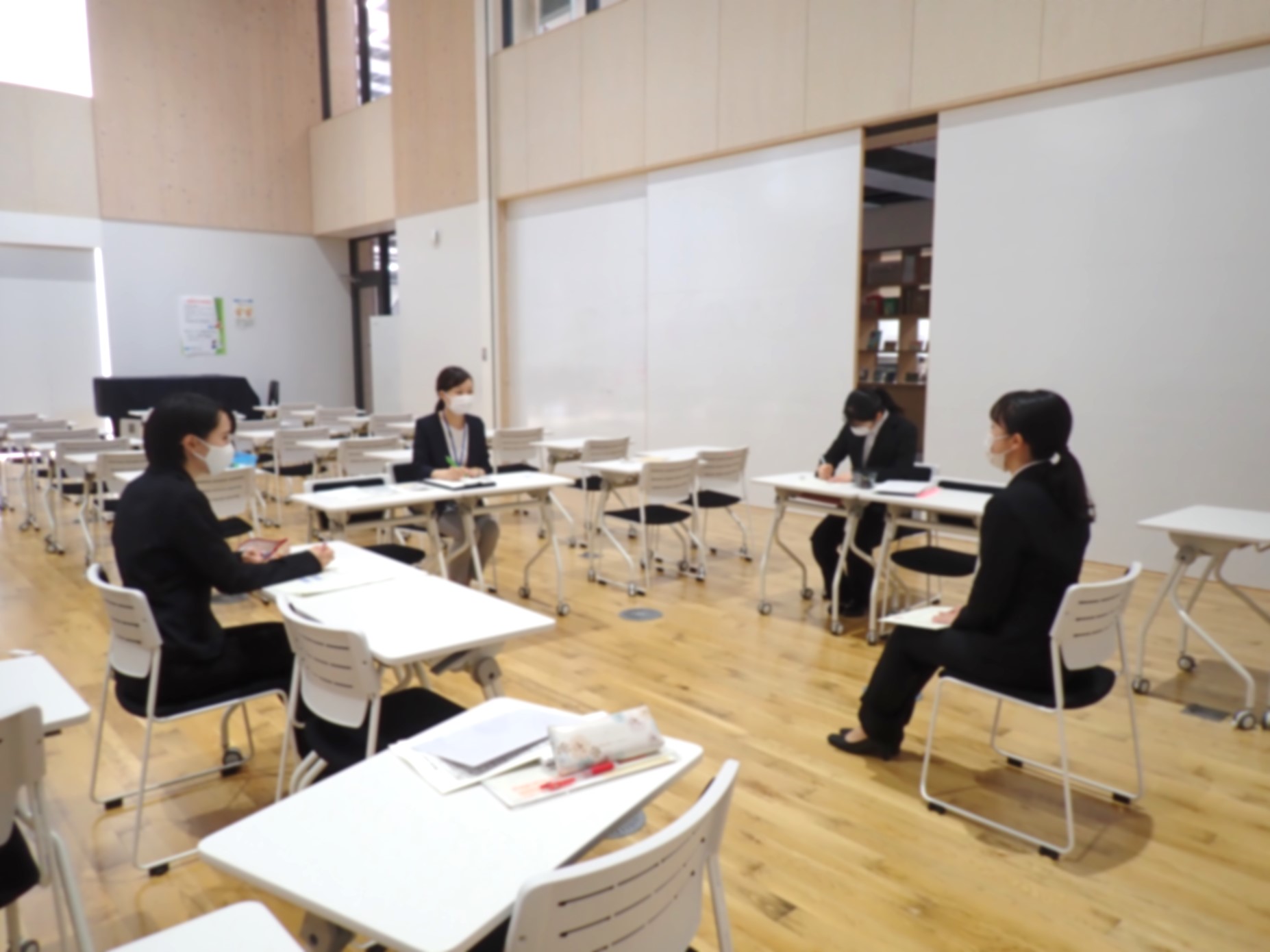 面接官1名と学生1名が向かい合って座り、模擬面接を行っている写真